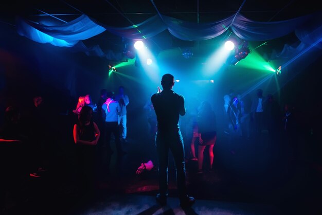 Silhouet van presentator op het podium tijdens concert in nachtclub