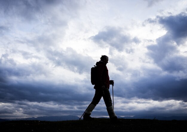 Silhouet van senior vrouw wandelen in de natuur