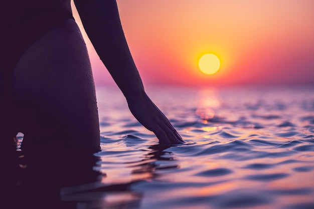 silhouet van sexy vrouw die zich voordeed bij zonsopgang op het strand