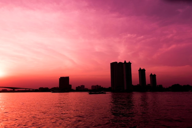 Foto silhouet van stad aan het water en rode lucht