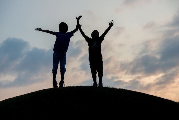 Silhouet van twee broers die van de vrijheid genieten