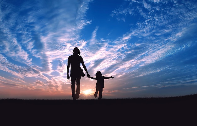 Silhouet van vader en zoon die bij zonsondergang op het veld staan