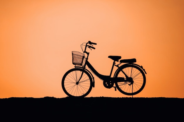 Silhouet van Vintage Bike, Racefiets op de weg op het platteland bij de rivier bij de zonsondergang,