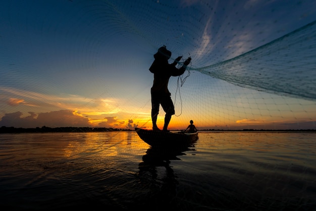 Silhouet van visser vissen op het meer