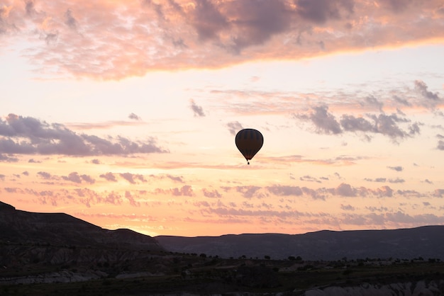 Silhouet van zwevende luchtballon over bergdal bij zonsopgang vintage vliegtuigen tijdens de vlucht