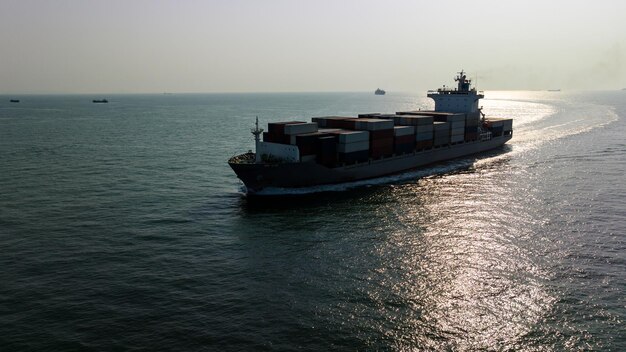 silhouet vrachtcontainerschip dat op zee vaart om in te voeren en uit te voeren