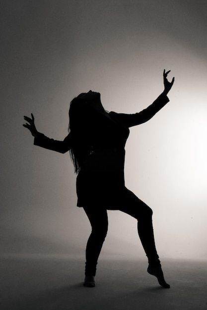 Foto silhouet vrouw die tegen de muur danst