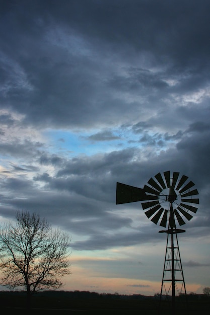 Silhouet waterpomp windmolen op het veld tegen de hemel tijdens zonsondergang