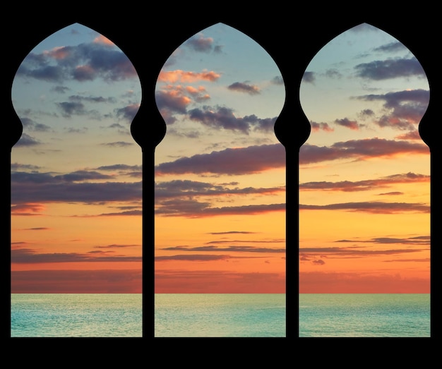 Silhouetbogen in het gebouw van de moskee op de achtergrond van de zee-zonsondergang