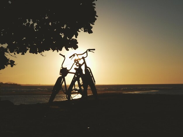 Foto silhouetfietsen aan wal op het strand