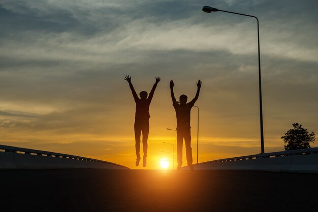 Silhouetparen die bij zonsondergang springen