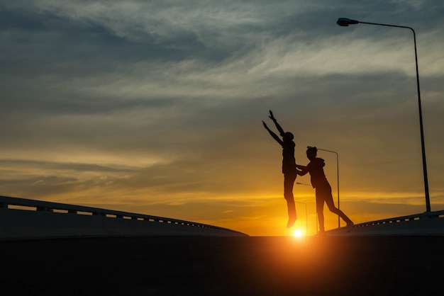 Silhouetparen die bij zonsondergang springen