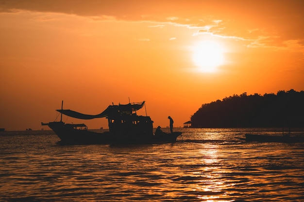 Silhouetscène van vissersboten op zee met gouden zonlicht in de ochtend
