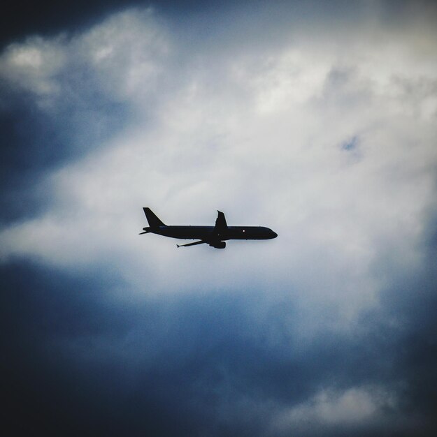 写真 夕暮れの雲の空に照らされたシルエット飛行機