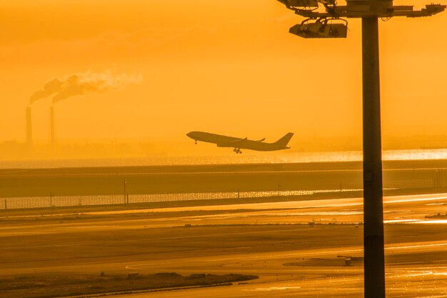 Silhouette airplane flying against sky during sunset