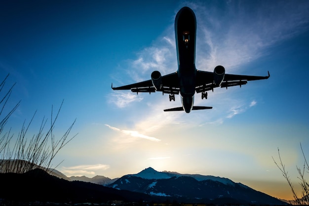 Silhouette airplane flying against sky during sunset