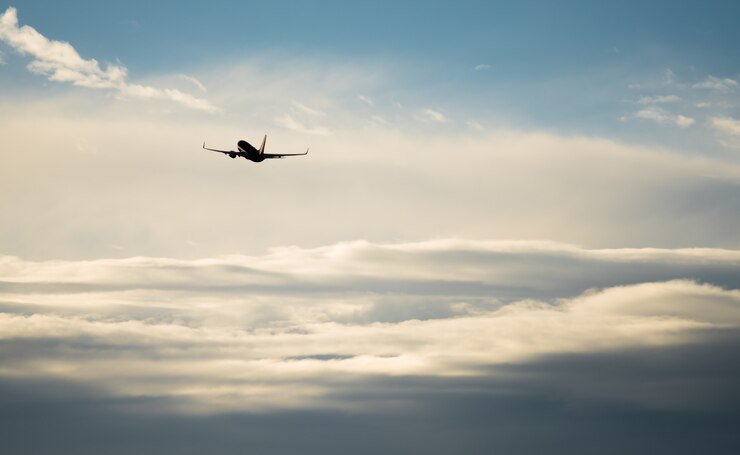 Photo silhouette airplane flying in the sky surround by blue cloud