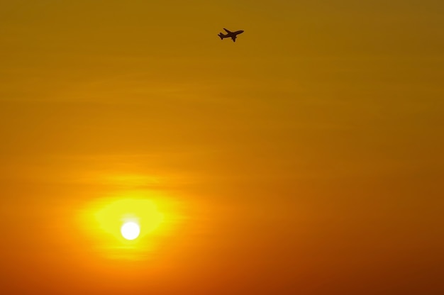 Silhouette of an airplane flying in sunset, shallow focus