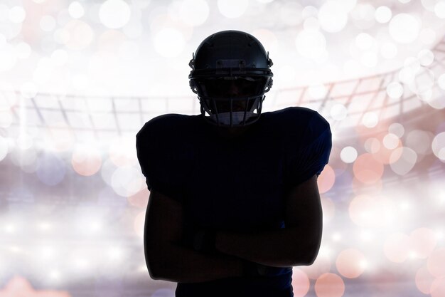 写真 光る背景に立っているシルエット アメリカン フットボール選手