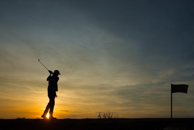 Silhouette asian golfer playing golf during beautiful sunset