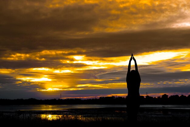 Silhouette of asian woman play yoga on sunset