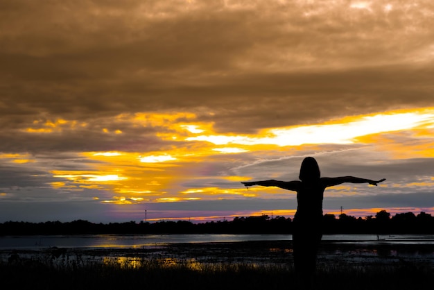 Silhouette of asian woman play yoga on sunset