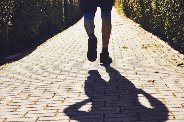 Foto siluetta dell'uomo dell'atleta che pareggia nel parco di sity di mattina