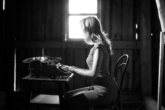 Silhouette of a beautiful girl in a dress on the background of a window in an old house