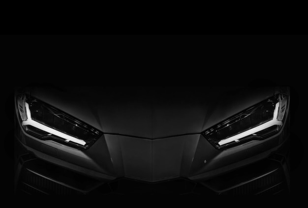 Silhouette of black sports car with LED headlights on black background