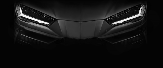 Silhouette of black sports car with LED headlights on black 