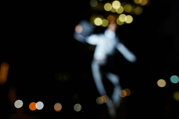 Silhouette of blurred dancing man at night