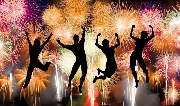 फोटो silhouette of boy and girl jumping happy enjoy brightly colorful fireworks in the night sky