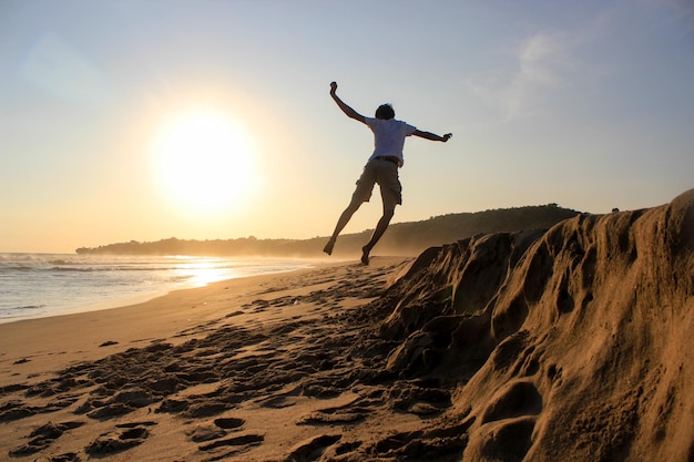 Silhouette of a boy jumping celebrating the sunset