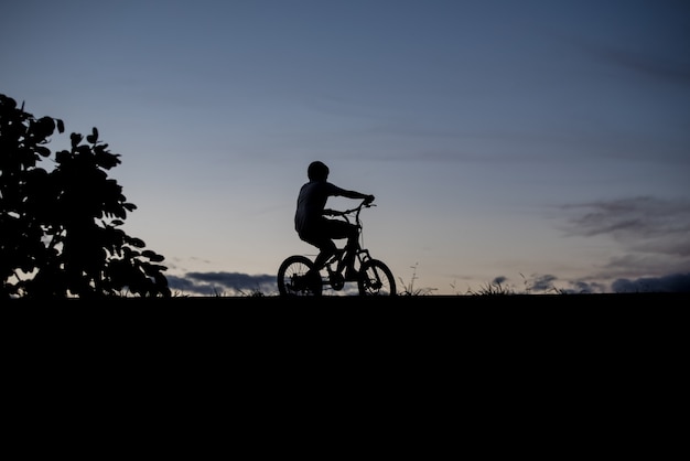 Silhouette of a boy riding a bicycle 