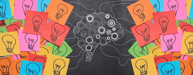 Photo silhouette of a brain with wheels and paper stickers with a drawn electric lamp