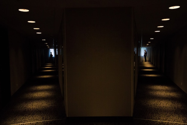 Silhouette of bride and bridegroom in dark corridor