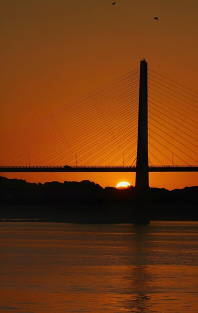 Foto silhouette bridge contro il cielo arancione durante il tramonto