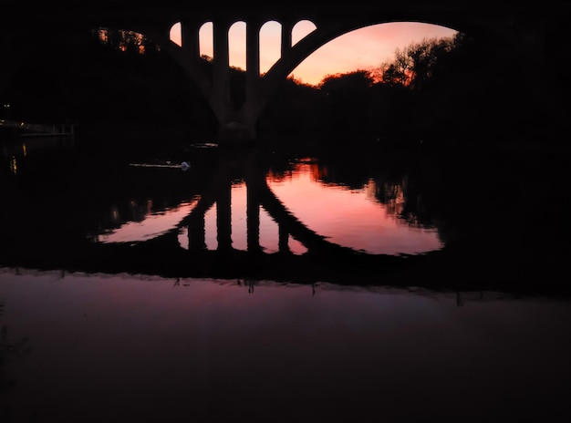 Photo silhouette bridge over river against sky during sunset