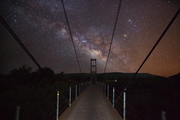 Silhouette of bridge with cloud and Milky Way Long exposure photograph
