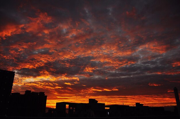 Photo silhouette of building against dramatic sky