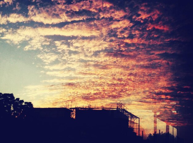 Foto silhouette di edifici contro un cielo nuvoloso durante il tramonto