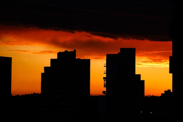 Photo silhouette buildings against dramatic sky during sunset