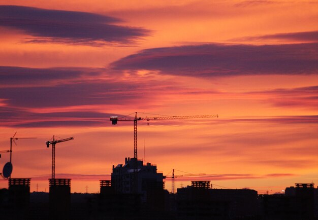 Photo silhouette of buildings against dramatic sky during sunset
