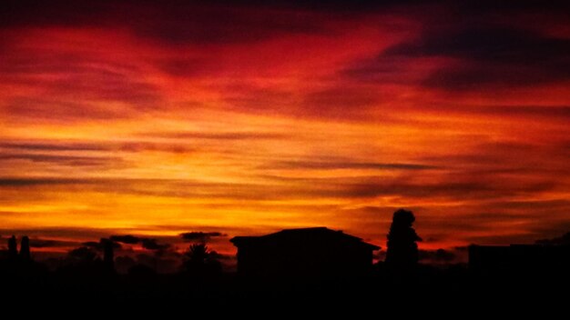 Silhouette buildings against orange sky