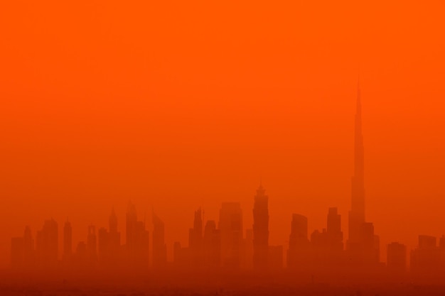 Silhouette buildings against orange sky