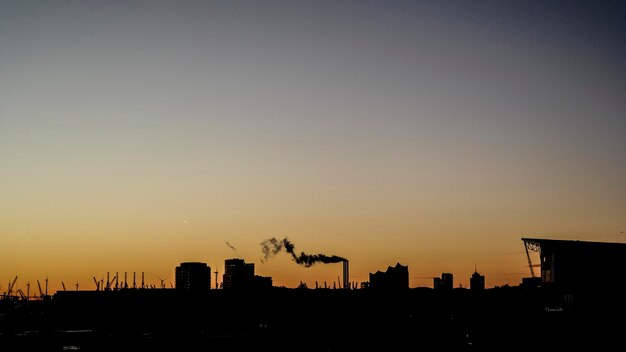 Photo silhouette buildings against sky during sunset