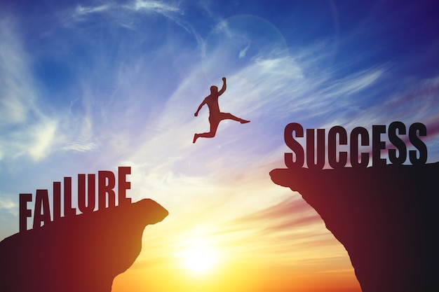 Silhouette of business man jump to success text over a beautiful high view