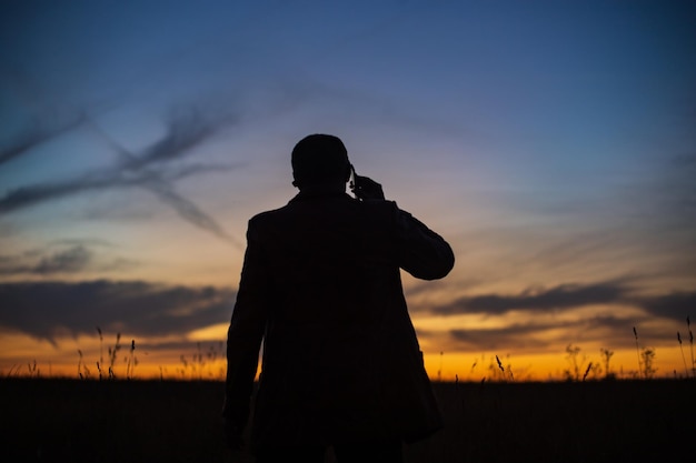 Foto silhouette di un uomo d'affari all'alba in natura il concetto di negoziazioni commerciali sviluppo successo start-up nuove opportunità