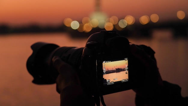 Photo silhouette of a camera capturing the sunset
