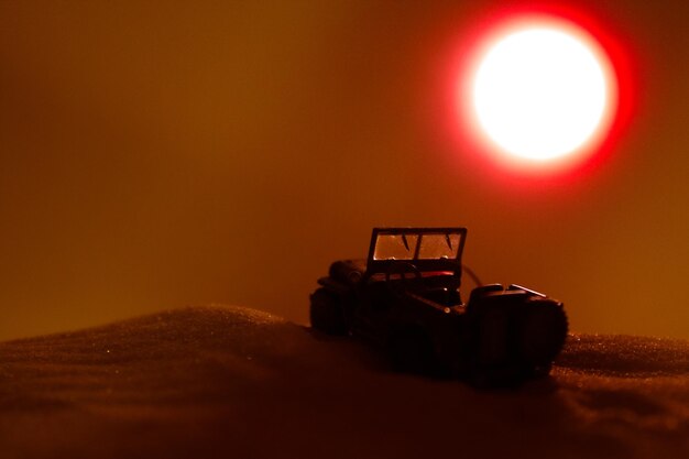 Silhouette car on land against sky during sunset